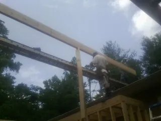 Carpenter setting a ridge beam over a new addition frame — Ice Dam Removal by Roofing Brothers in Lake Oswego