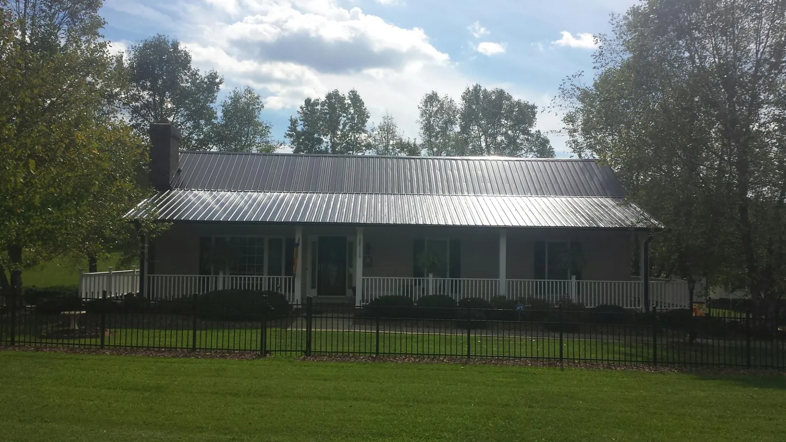Gray metal roof on a brick ranch with a full width front porch — Gutter Guard Installation work by our crew in Lake Oswego