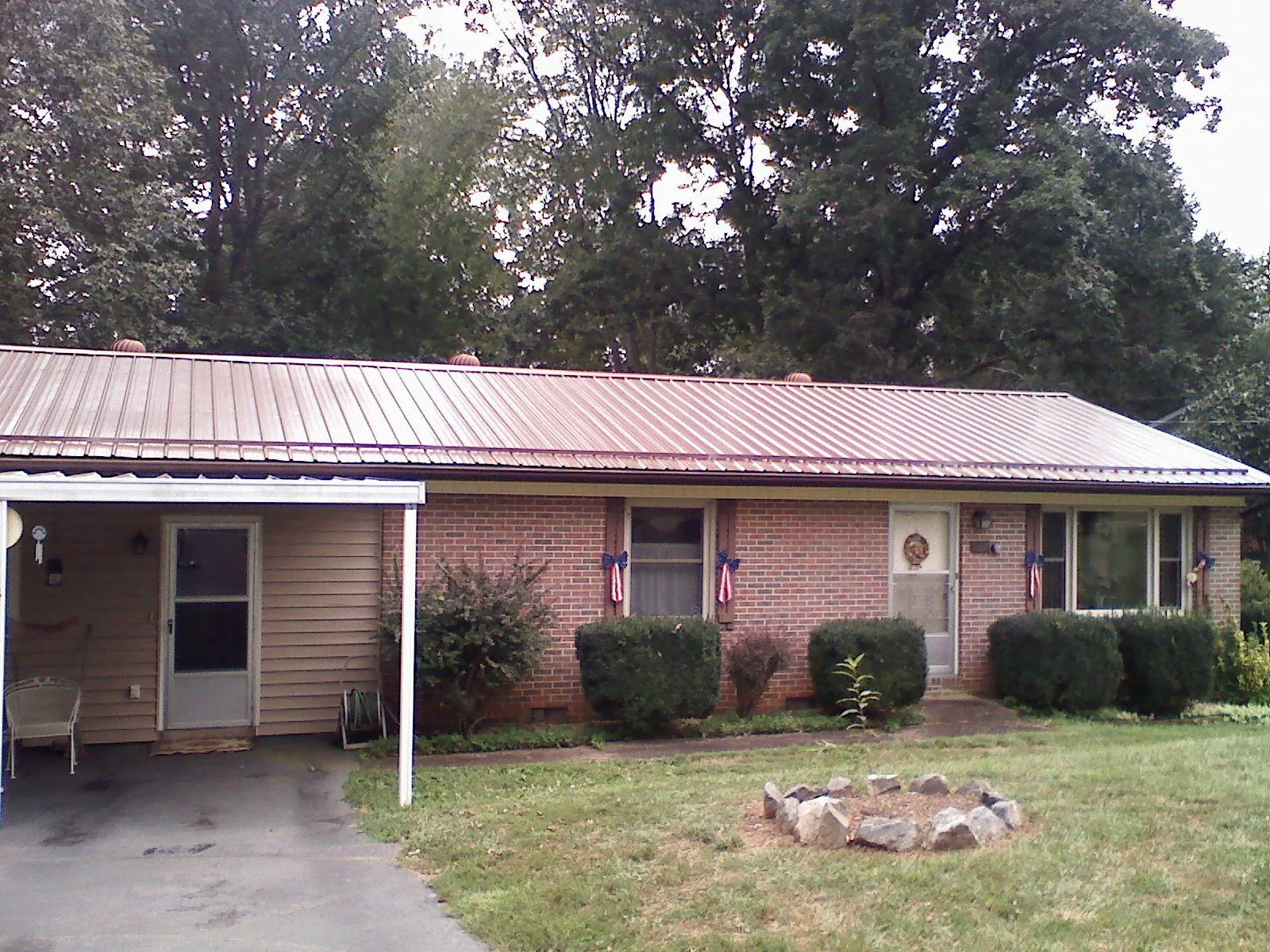 Bronze metal roof and carport on a brick ranch home — Roof Repair work by our crew in Lake Oswego